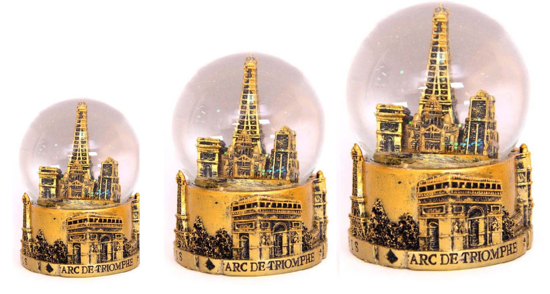 Boule de neige dorée avec les monuments de Paris, y compris la Tour Eiffel et Notre-Dame, sous la neige scintillante. Souvenir Paris